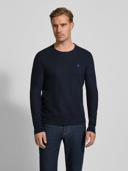 Männermodel trägt dunkelblauen Strickpullover mit Label-Stitching von Polo Ralph Lauren, reine Baumwolle, Ganzkörperansicht von vorne.