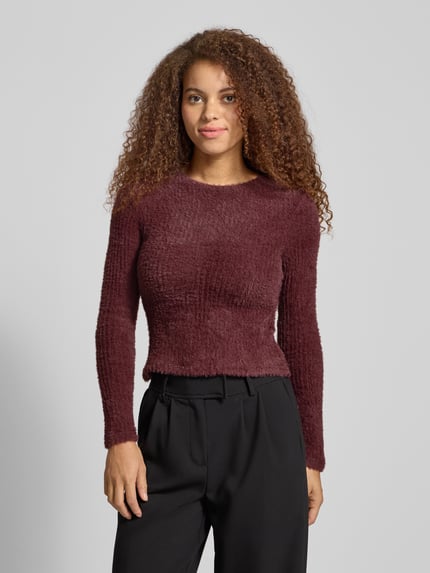 Frauenmodel trägt Slim Fit Strickpullover Modell 'VIOLA' von Only, unifarben in Bordeaux, Rundhals, langarm, Nahaufnahme Oberkörper.