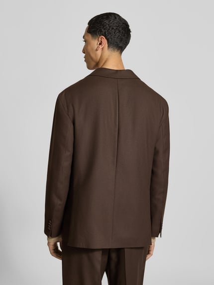 Männermodel trägt Regular Fit Sakko aus reiner Schurwolle von Officine Générale in Braun, feine Webstruktur, Ganzkörperansicht Rückansicht. Rückenlänge 73 cm, Schulterbreite 46 cm, Ärmellänge 62 cm, Reverskragen und aufgesetzte Eingrifftaschen.