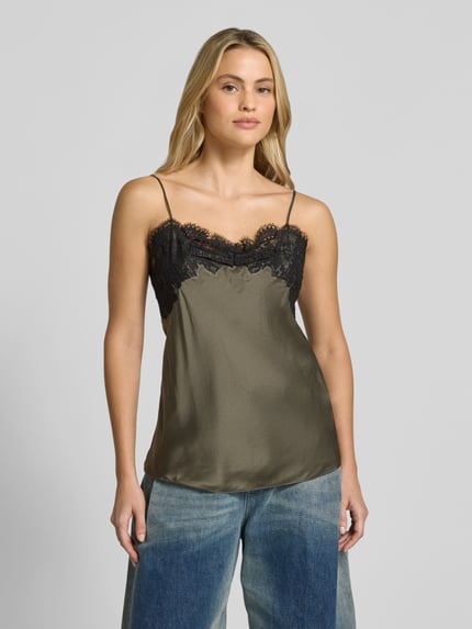 Frauenmodel trägt Top aus reiner Seide von Iro, olivgrüner Satin mit schwarzem Spitzenbesatz, ärmellos, leicht tailliert, Ganzkörperansicht von vorne.
