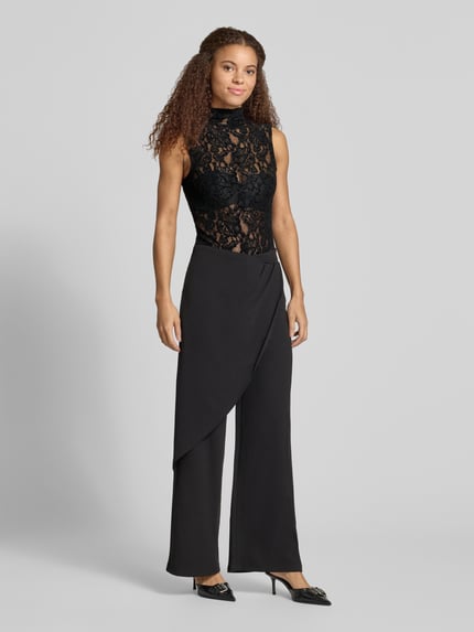 Frauenmodel trägt schwarzes Top aus Spitze mit Stehkragen Modell 'COCO' von Topshop, Slim Fit, Mix aus transparenten Texturen, Ganzkörperansicht von vorne.
