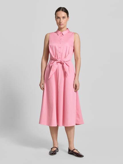 Frauenmodel trägt Hemdblusenkleid aus Satin in Midilänge von Comma, elastischer Baumwoll-Mix, taillierte Passform, ärmelloses Design in Rosa mit durchgehender Knopfleiste und abnehmbarem Taillenband, Ganzkörperansicht von vorne.