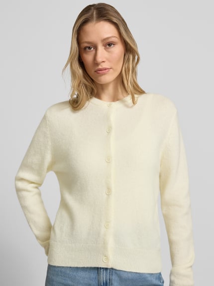Frauenmodel trägt Regular Fit Cardigan aus Alpaka-Mix von Samsøe Samsøe in Creme, Strick-Optik, Knopfleiste, Rundhals, Nahaufnahme Oberkörper.