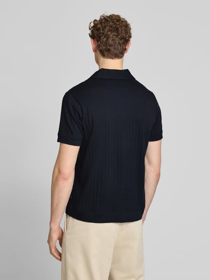 Männermodel trägt Regular Fit Poloshirt mit durchgehender Knopfleiste von JOOP! Collection aus reiner Baumwolle in Dunkelblau, Ganzkörperansicht Rückansicht.