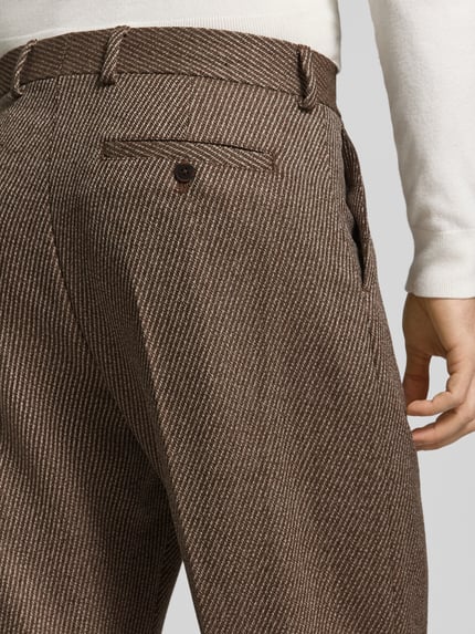 Männermodel trägt Regular Fit Bundfaltenhose aus Wolle von Selected Homme, Fischgräten-Muster, braun-beige, Detailaufnahme, KI-modifiziertes Bild.