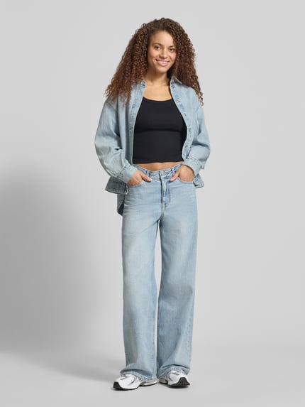 Vrouwenmodel draagt Slim Fit Top aus Baumwoll-Mix Modell 'ESSENTIAL RIBBED TANK' van Levi's®, effen zwart, fijne ribstructuur, label patch, U-hals, van voren, geheellichaamszicht.