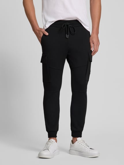 Männermodel trägt Regular Fit Sweatpants mit Cargotaschen von Antony Morato aus Baumwoll-Mix in Schwarz, Nahaufnahme Unterkörper.