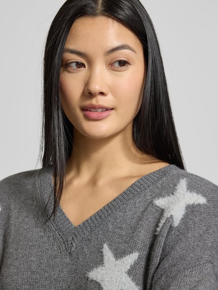 Vrouwenmodel draagt Loose Fit Strickpullover mit Kaschmir-Anteil van Smith and Soul, grijs met witte sterren, V-hals, katoenmix, Nahaufnahme bovenlichaam.
