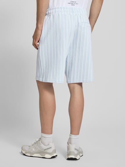 Männermodel trägt Straight Fit Shorts mit Strukturmuster Modell 'Forno' von Pegador aus Reine Baumwolle, Strukturmuster, Rückansicht.