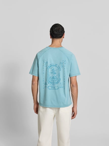 Mannenmodel draagt Regular Fit T-shirt met logoprint van MAISON KITSUNÉ in lichtblauw biologisch katoen, korte mouw, ruglengte maat M: 70 cm, ganzkörperansicht rückansicht.