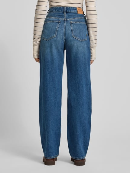 Frauenmodel trägt Jeans mit Eingrifftaschen Modell 'THE RIPPLE' von Scotch & Soda in Blau, reine Baumwolle, Straight Fit, Ganzkörperansicht Rückansicht.