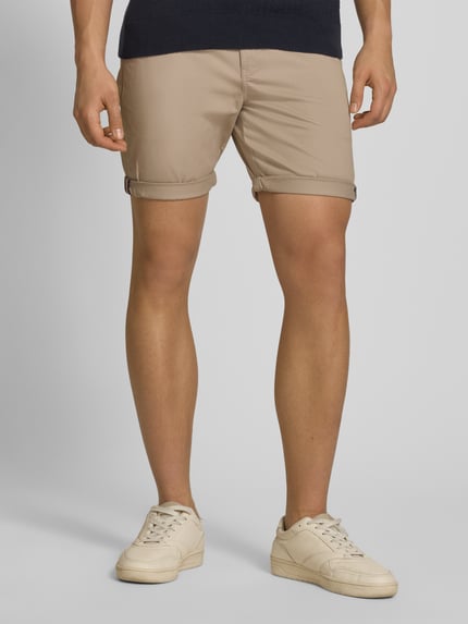 Männermodel trägt Regular Fit Shorts mit Münztasche van Superdry in beige katoenmix met achterzakken, knoop- en ritssluiting, Ganzkörperansicht von vorne.
