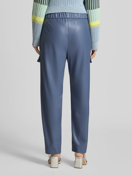 Frauenmodel trägt Straight Fit Hose in Leder-Optik mit Pattentaschen von Marc Cain in Blau, elastischer Bund, Ganzkörperansicht Rückansicht.