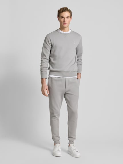 Männermodel trägt Sweatpants mit elastischem Bund von Polo Ralph Lauren aus Baumwoll-Mix, Lockerer-Schnitt, helle Farben, Ganzkörperansicht von vorne. Innenbeinlänge bei Größe M beträgt 76 cm, mit Tunnelzug, französischen Eingrifftaschen und Gesäßtasche.