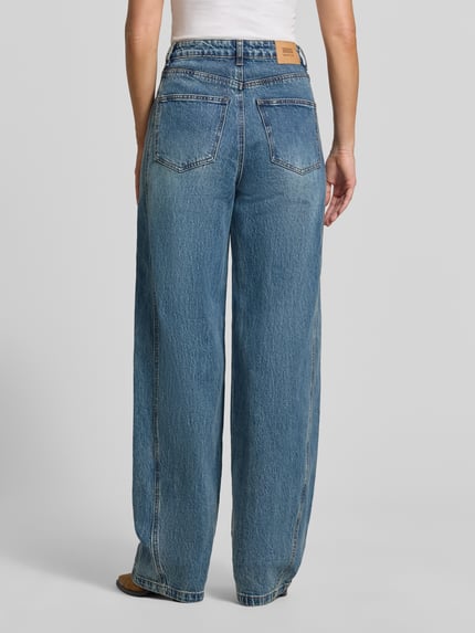 Frauenmodel trägt Barrel Fit Jeans aus Baumwoll-Mix Modell 'Melu' von GESTUZ, mittleres Blau, 5-Pocket, Ganzkörperansicht Rückansicht. Baumwoll-Elasthan-Mix, Knopf- und Reißverschluss, Bundweite 39 cm, Innenbeinlänge 86 cm.
