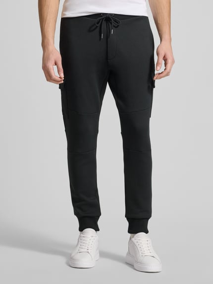 Männermodel trägt Sweatpants mit elastischem Bund von Polo Ralph Lauren aus Baumwoll-Elasthan-Mix, Label-Detail, lockerer Schnitt, Ganzkörperansicht von vorne.
