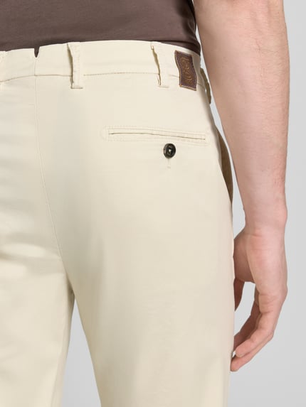 Männermodel trägt Slim Fit HOSE Modell 'Tybalt 5' von g1920 in Beige, Baumwoll-Lyocell-Anteil, Eingrifftaschen, Soft Touch, Detailaufnahme Rücken.