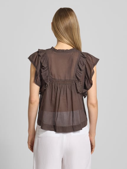 Frauenmodel trägt Bluse mit Volants Modell 'Jayla' von Neo Noir aus brauner Baumwolle, lockerer Schnitt, Rückansicht, Ganzkörperansicht.