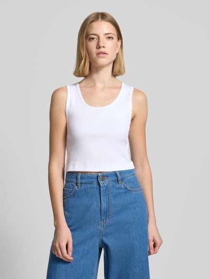 Vrouwenmodel draagt wit slim fit dames top van puur katoen met sierborduur, model 'Tiora' van Drykorn, voorkant bovenlichaam.