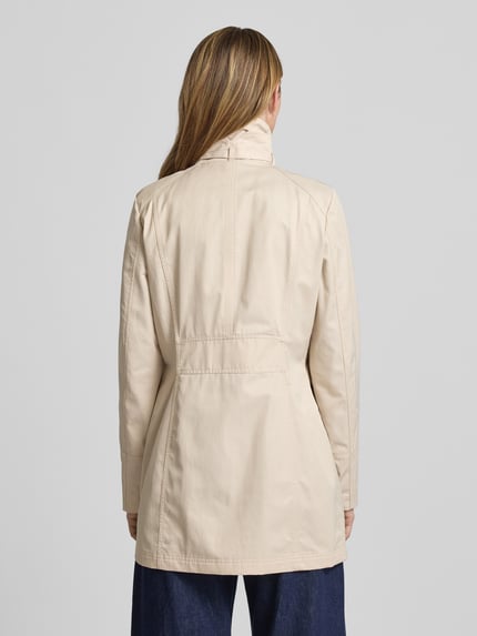 Frauenmodel trägt Trenchcoat mit Stehkragen und Eingrifftaschen von Fuchs Schmitt in Beige, taillierter Schnitt, Baumwoll-Mix, Ganzkörperansicht Rückansicht