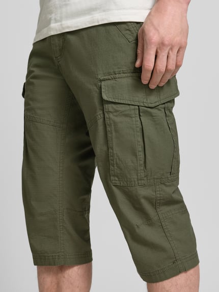 Männermodel trägt Relaxed Fit Cargoshorts aus Baumwoll-Mix von s.Oliver BLACK LABEL, Optik: Unifarben, Label-Patch, seitliche Eingrifftaschen, Popeline, Ganzkörperansicht Rückansicht.
