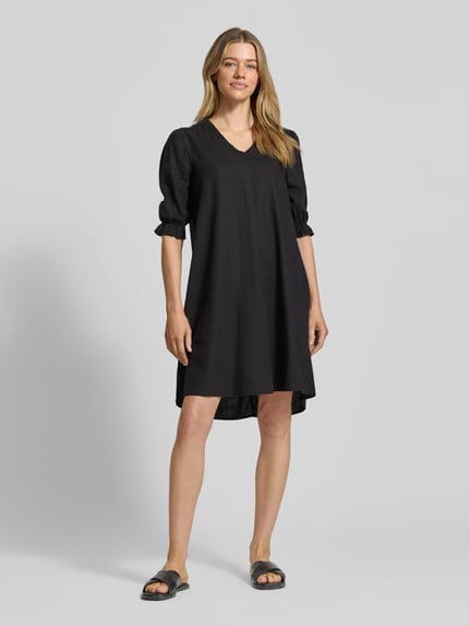 Vrouwenmodel draagt knielang dames jurk van B.Young, mix van linnen en viscose, recht model, V-hals, ruches, model 'FALAKKA', zwart, geheel van voren.