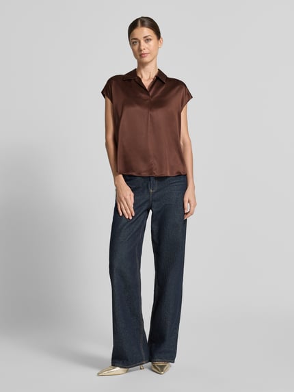 Frauenmodel trägt Regular Fit Hemdbluse aus reiner Seide von Luisa Cerano in Braun, glatte Oberfläche, kombiniert mit Jeans, Ganzkörperansicht von vorne. Rückenlänge bei Größe 36: 60 cm, Hemdblusenkragen, gelegte Falte, kurzärmeliges Design.