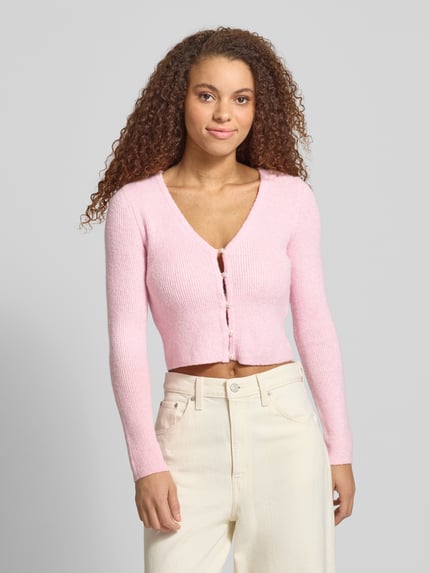 Frauenmodel trägt Regular Fit Strickjacke mit Perl-Optik-Knöpfen Modell 'RICA LIFE' von ONLY, Optik: Unifarben, Rippstrick, V-Ausschnitt, Langarm, Knopfleiste, Nahaufnahme Oberkörper.