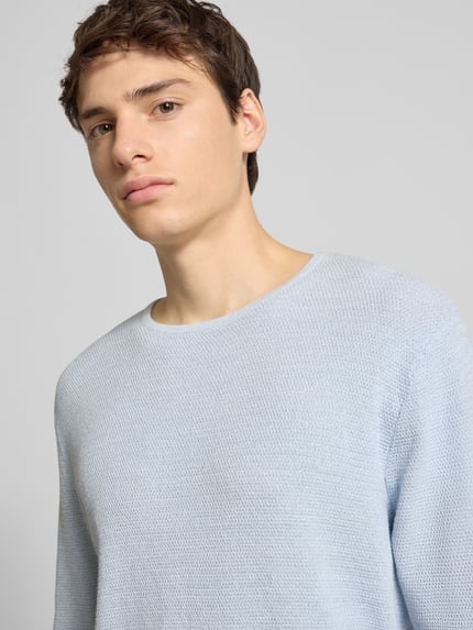 Männermodel trägt Strickpullover mit geripptem Rundhalsausschnitt Modell 'GEORGE' von Jack & Jones aus Baumwoll-Mix, Lockerer-Schnitt, Nahaufnahme Oberkörper.