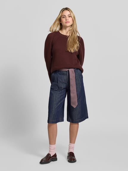 Frauenmodel trägt Pullover mit ausgestelltem Ärmel Modell 'Maple' von Joseph in unifarbener Strickoptik, Struktur, Regular Fit, cropped Länge, Rundhalsausschnitt, langarm mit Raglan und geripptem Rumpfabschluss, Feinstrick, Ganzkörperansicht von vorne.