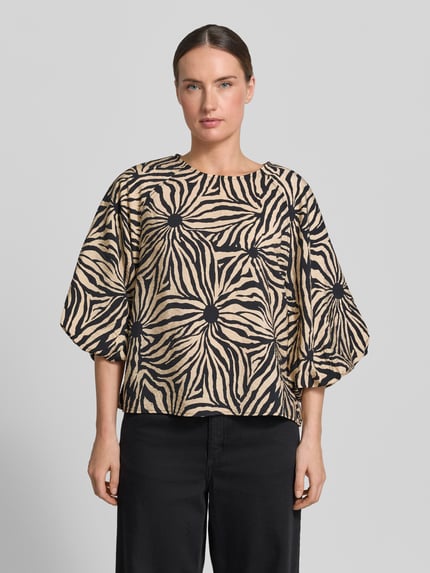 Frauenmodel trägt Regular Fit Bluse aus Viskose-Mix im Allover-Look von Christian Berg Woman in Beige und Schwarz mit Rundhalsausschnitt, 3/4-Arm, Rückenlänge bei Größe 36: 56 cm, Ärmellänge bei Größe 36: 45 cm, Ganzkörperansicht von vorne.
