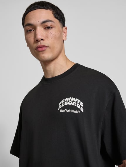 Mannelijk model draagt Regular Fit T-Shirt uit puur katoen model 'PEANUTS' van Only & Sons in zwart met Peanuts® print, ronde hals, korte mouw, jersey, detailopname bovenlichaam.