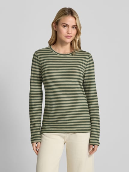 Modelka nosi Regular Fit Langarmshirt aus reiner Baumwolle von Marc O'Polo, zielono-beżowe paski, gładka tekstura, Ganzkörperansicht von vorne.