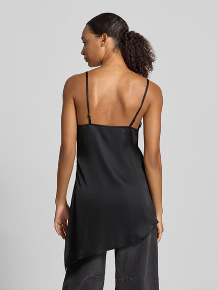 Männermodel trägt A-Linie Freizeitkleid mit Spitzenbesatz Modell 'ELVA' von PIECES, czarny kolor, asymetryczny dół, cienkie ramiączka, widok całej sylwetki z tyłu