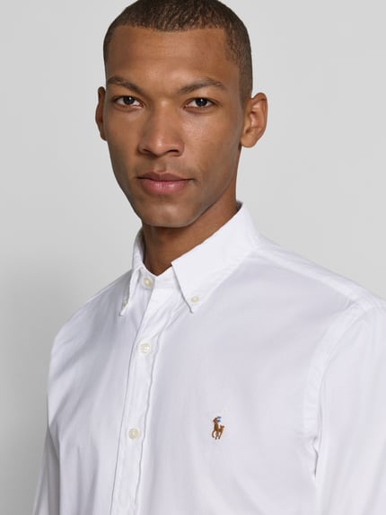 Männermodel trägt weißes Regular Fit Freizeithemd aus Baumwoll-Mix von Polo Ralph Lauren, glatte Struktur, Nahaufnahme Oberkörper.