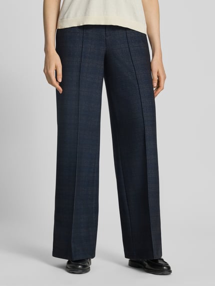 Kobieta nosi spodnie 'Wide Fit Hose mit Viskose-Anteil' od Oui, mieszanka wiskozy, ozdobne szwy, kieszenie z tyłu, zapięcie na haftkę i zamek błyskawiczny, ciemnoniebieskie, szerokie nogawki, szerokość w rozmiarze 36: 39 cm, długość wewnętrzna nogawki: 80 cm, widok na całe ciało z przodu.