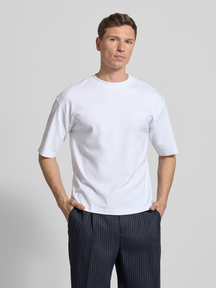 Männermodel trägt weißes Relaxed Fit T-Shirt aus reiner Bio-Baumwolle von JAKE*S STUDIO MEN, Halbarm, Rundhalsausschnitt, Ganzkörperansicht von vorne.