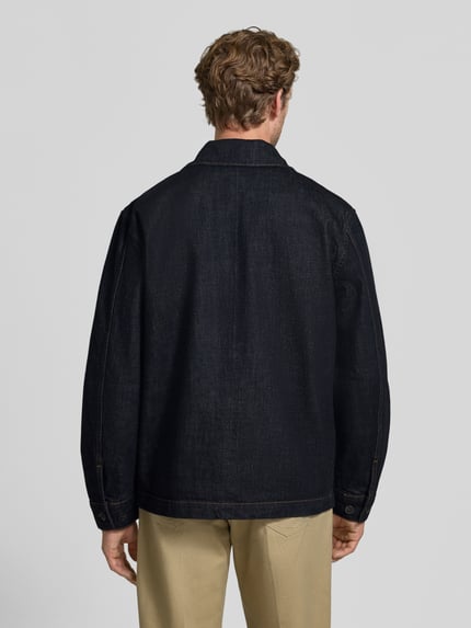 Männermodel trägt Regular Fit Freizeithemd aus reiner Baumwolle Modell 'JOE SELVEDGE' von Selected, dunkles Blau, lockere Passform, Herren Freizeithemd, Ganzkörperansicht Rückansicht.