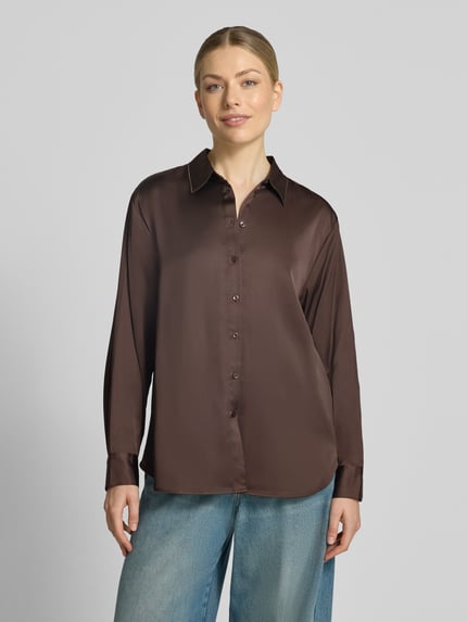 Frauenmodel trägt Relaxed Fit Hemdbluse aus Viskose-Mix von COMMA in Braun mit Hemdblusenkragen und Knopfleiste, Ganzkörperansicht von vorne. Rückenlänge 69 cm, Ärmellänge 60 cm, glatte Textur mit leichtem Glanz.