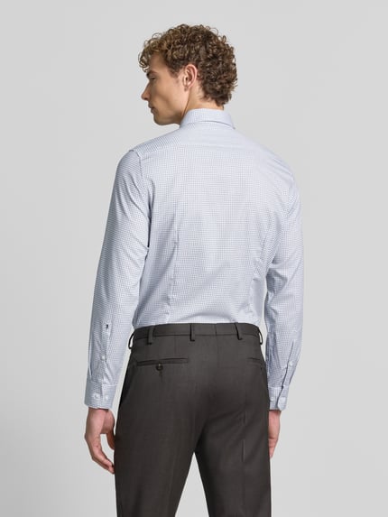 Männermodel trägt Slim Fit Businesshemd aus reiner Baumwolle Modell 'New B.D.' von Seidensticker, helles Karomuster, Ganzkörperansicht Rückansicht, Herren Businesshemd von Seidensticker.