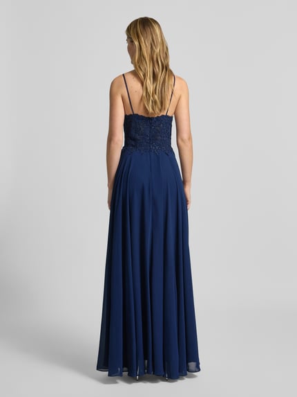 Frauenmodel trägt Regular Fit Abendkleid mit Strasssteinbesatz von Mascara in Dunkelblau, Spitzenbesatz, semitransparent, Rückansicht, Ganzkörperansicht.