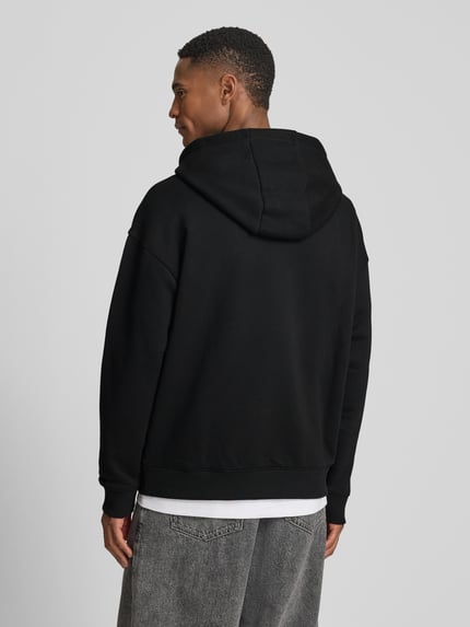 Männermodel trägt Regular Fit Hoodie aus reiner Baumwolle Modell 'DAGETHOOD' von HUGO, Optik: Unifarben, Sweat, Ganzkörperansicht Rückansicht.