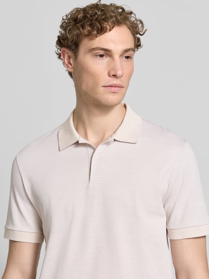 Männermodel trägt Regular Fit Poloshirt aus reiner Baumwolle Modell 'H-PARLAY 102' von BOSS in Bi-Color Optik, Nahaufnahme Oberkörper.