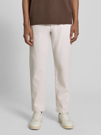 Männermodel trägt Tapered Fit Chino aus Baumwoll-Mix Modell 'CHINO PLEATED' von BOSS Orange, Optik: Unifarben, Twill-Textur, Ganzkörperansicht von vorne.