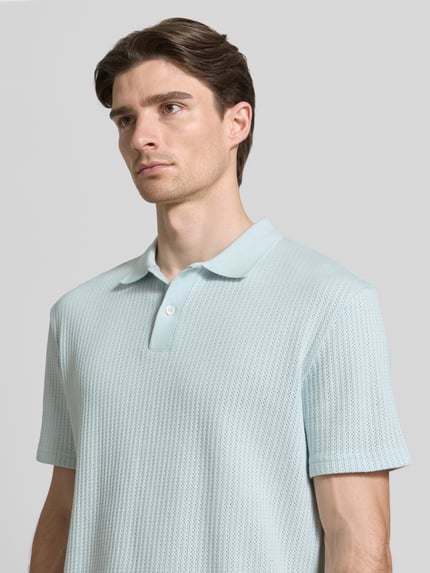 Männermodel trägt Regular Fit Poloshirt aus Baumwolle Modell 'JASE' von Samsøe Samsøe in Hellblau mit Feinstruktur, Nahaufnahme Oberkörper. Herren Poloshirt, reine Baumwolle, Polokragen, Rückenlänge Größe M 64 cm.