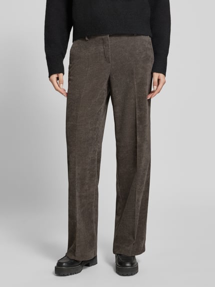 Frauenmodel trägt braune Regular Fit Cordhose mit Bundfalten Femke 2-800 von Stehmann, Strukturmuster, seitliche und Gesäßtaschen, Nahaufnahme Unterkörper.