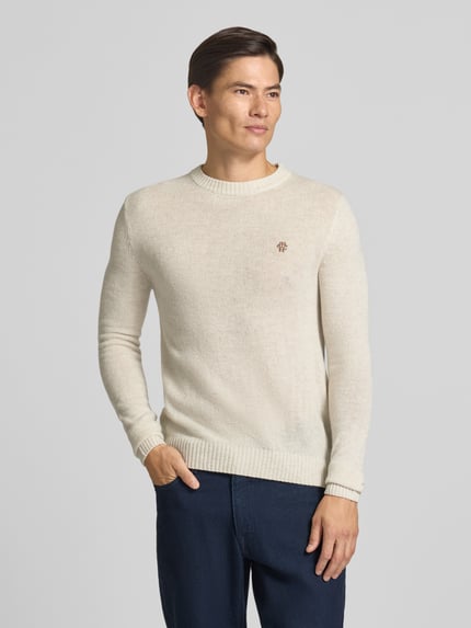 Mannenmodel draagt gebreide pullover Slim Fit Strickpullover aus reiner Wolle mit Label-Stitching van MCNEAL, zuiver wol, slim fit, labelstitching, ribboorden, ruglengte maat M 66 cm, mouwlengte maat M 69 cm, lichte beige kleur, eenvoudige textuur, rechte vormen, Ganzkörperansicht van voren.