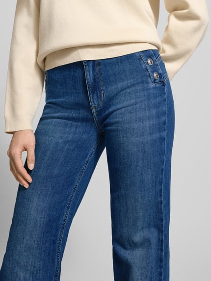 Vrouwenmodel draagt Flared Jeans met Knopen van Liu Jo White in blauw, katoenmix met stretch, used-look, detailopname taille en bovenbenen.