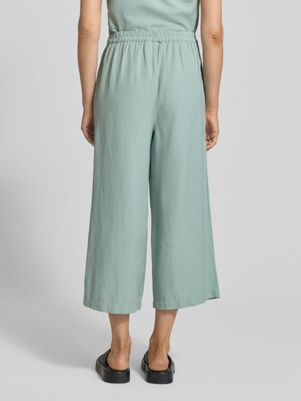Frauenmodel trägt Culotte aus Viskose-Mix mit Leinen-Anteil Modell 'PRISILLA' von Vila, Loose-Fit, elastischer Bund, Eingrifftaschen, Ganzkörperansicht Rückansicht.