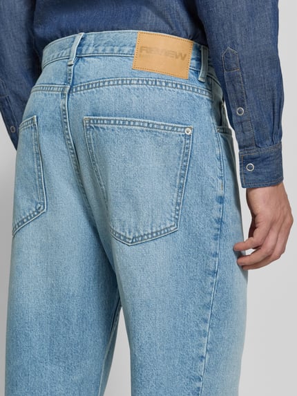 Männermodel trägt Baggy Fit Jeans mit Knopfverschluss von REVIEW, hellblauer Denim, 5-Pocket-Design, Rückansicht, Detailaufnahme